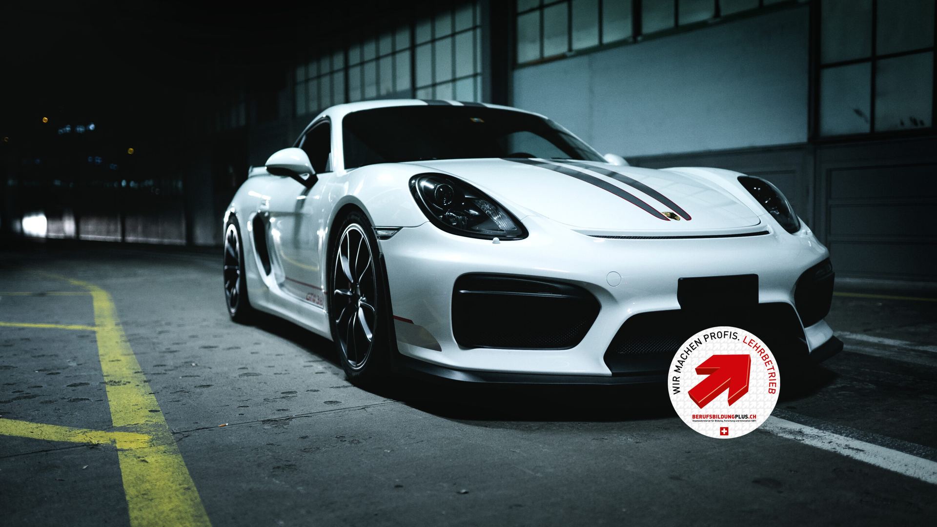 Weisser Porsche Cayman GT4 – Lehrbetrieb-Signet Berufsbildungplus